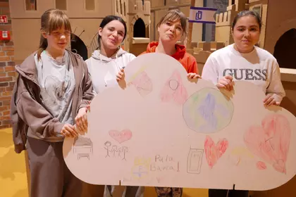 Grupa dzieci prezentuje kolorową pracę plastyczną.