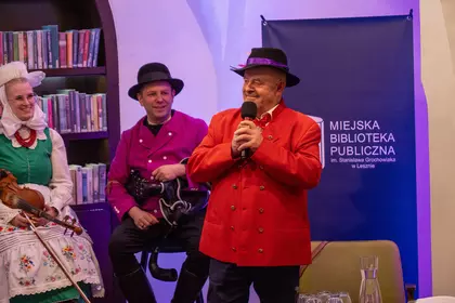 Mężczyzna przemawia do mikrofonu podczas spotkania z publicznością.