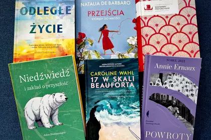 Kilka książek ustawionych obok siebie na ciemnym tle.