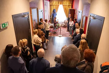 Publiczność zgromadzona na wydarzeniu w historycznym wnętrzu.