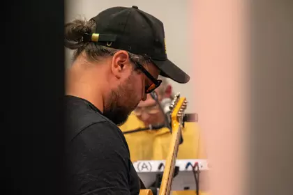 Gitarzysta gra na gitarze elektrycznej podczas koncertu.