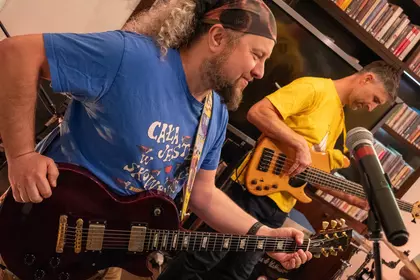 Muzycy grają na gitarach podczas występu.
