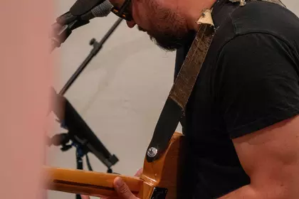 Zbliżenie na gitarzystę grającego podczas koncertu.