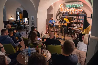 Zespół występuje na scenie przed publicznością w Bibliotece Ratuszowej.