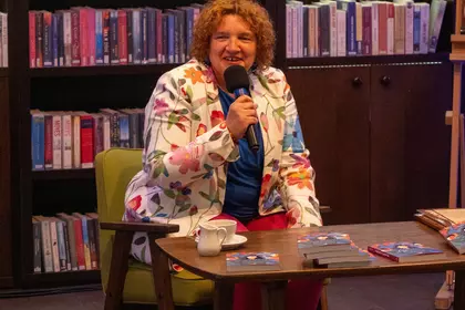 Agata Rusak trzyma mikrofon podczas rozmowy o książce „Zaplątani w pępowinie”.