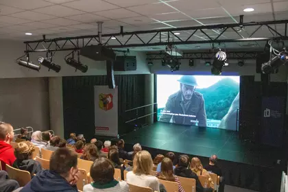 Publiczność ogląda pokaz filmu w sali audiowizualnej biblioteki.