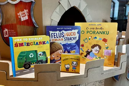 Książki dla dzieci ustawione w kartonowym zamku w bibliotece