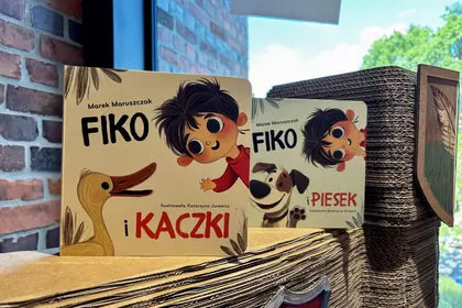 Książki „Fiko” ustawione na kartonowej wieży przy oknie