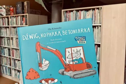 Książka o koparce i betoniarce trzymana w dziale dziecięcym