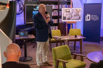 Prowadzący spotkanie o Milesie Davisie przemawia w Bibliotece Ratuszowej.