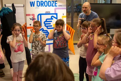 Uczestnicy zajęć biorą udział w ruchowej zabawie edukacyjnej.
