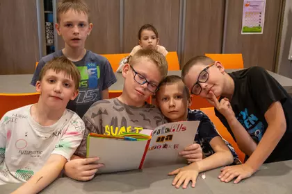 Dzieci pozują do zdjęcia z własnoręcznie zrobioną książki.