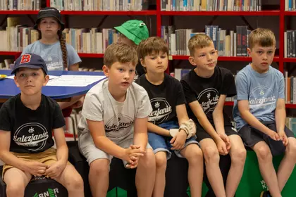 Dzieci uczestniczą w zajęciach edukacyjnych w przestrzeni biblioteki.
