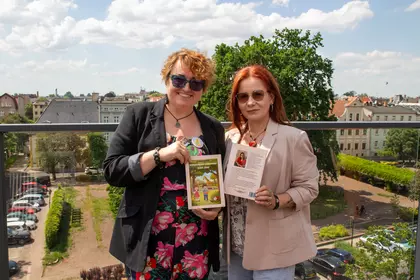 Autorki pozują do zdjęcia z książką.