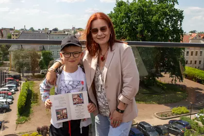 Kobieta z dzieckiem pozują do zdjęcia na dachu.