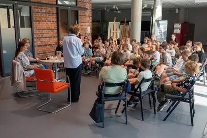 Uczestnicy spotkania autorskiego słuchają opowieści i rozmowy z autorką