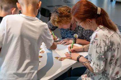 Autorka i ilustratorka podpisują pamiątkowe przypinki dla uczestników spotkania
