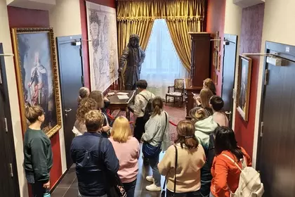 Zwiedzający słuchają opowieści o historii Leszna w tematycznej przestrzeni.