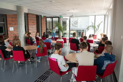Młodzież uczestniczy w prelekcji w bibliotece.