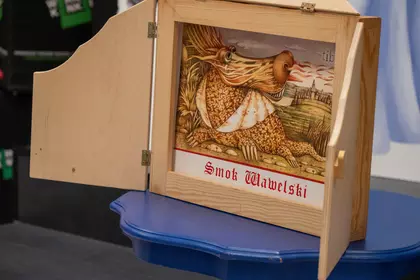 Ilustracja Smoka Wawelskiego prezentowana w drewnianym teatrzyku kamishibai.