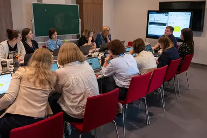 Uczestnicy szkolenia pracują przy komputerach podczas zajęć z kompetencji cyfrowych.