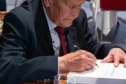 Edmund Waszyński podpisuje egzemplarz swojej książki.