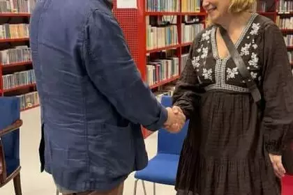 Dyrektor biblioteki wita nauczycielkę uczestników wydarznia.