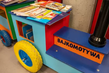 Kolorowa Bajkomotywa wypełniona książkami dla najmłodszych czytelników.