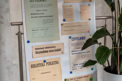 Tablica z archiwalnymi ogłoszeniami i materiałami bibliotecznymi