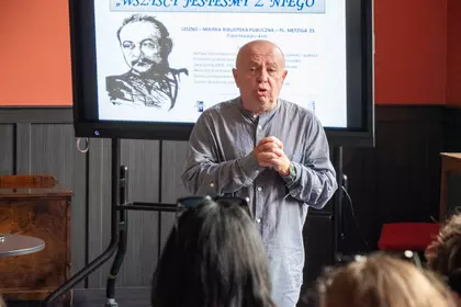 Prelegent przemawia na tle prezentacji poświęconej Stanisławowi Grochowiakowi.