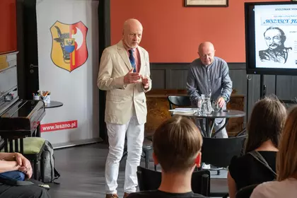 Prowadzący spotkanie wita uczestników wydarzenia w Salonie Maciejewskich.