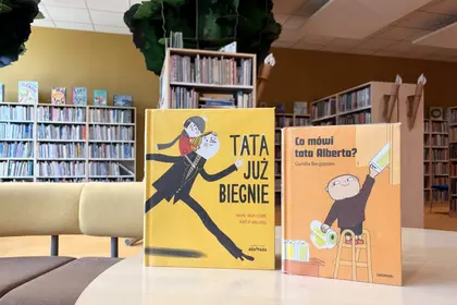 Dwie książki dla dzieci o tatach stoją na stoliku w Wypożyczalni dla Dzieci.