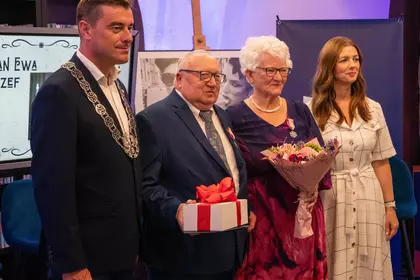 Para małżeńska po otrzymaniu medali, kwiatów i upominku.