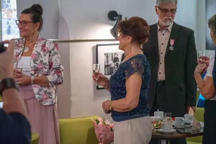 Goście spotkania świętują jubileusz przy wspólnym stole.
