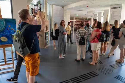 Goście ze Śremu poznają przestrzenie biblioteki podczas oprowadzania.