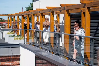 Bibliotekarze spacerują po tarasie widokowym biblioteki.