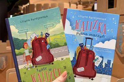Książki „Teatr w walizce” i „Walizka pełna marzeń” w dziecięcej bibliotece.