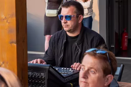 Realizator dźwięku obsługuje koncert na dachu biblioteki.