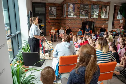 Uczestnicy z zainteresowaniem słuchają opowieści o zwierzętach.