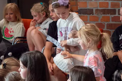 Uczestnicy skupieni na prezentacji o zwierzętach i adopcji.