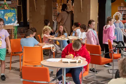 Uczestnicy tworzą rysunki zwierząt na materiałowych torbach.