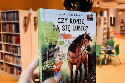 Książka „Czy konie da się lubić?” prezentowana w bibliotece.