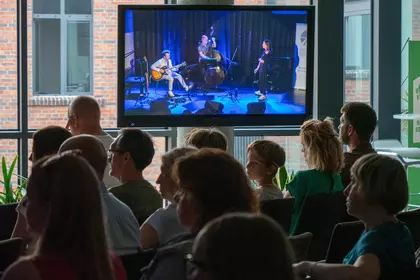 Transmisja koncertu wyświetlana na ekranie dla publiczności