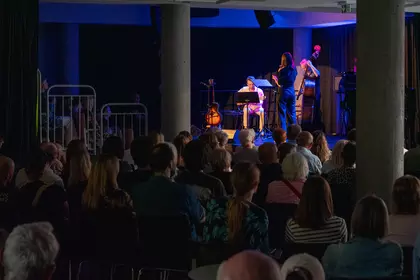 Publiczność uczestniczy w koncercie jazzowym w bibliotece