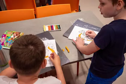 Dzieci wyklejają plasteliną smoki inspirowane legendą wawelską.