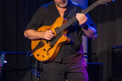 Marek Napiórkowski skupiony podczas gry na gitarze.