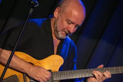 Marek Napiórkowski skupiony podczas gry na gitarze.