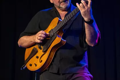 Marek Napiórkowski skupiony podczas gry na gitarze.