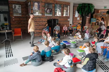 Pracownik Mini Zoo opowiada dzieciom o żywieniu zwierząt.