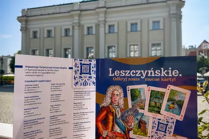 Broszura na tle wieży Ratusza w Lesznie.